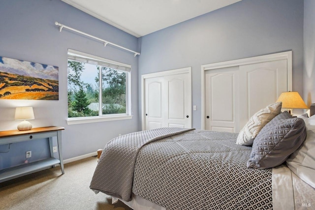 bedroom with carpet and two closets