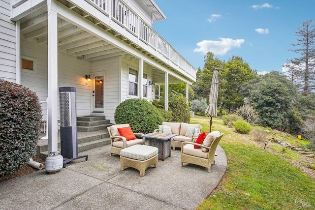 view of patio with an outdoor living space with a fire pit