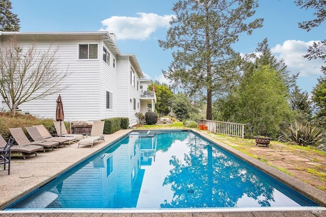 view of swimming pool featuring a patio area and a fire pit