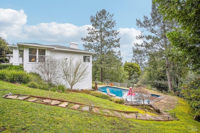 view of swimming pool with a yard