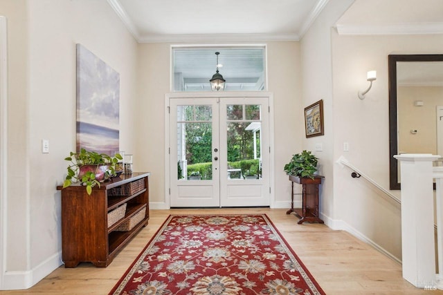 entryway featuring crown molding, light wood-type flooring, and french doors