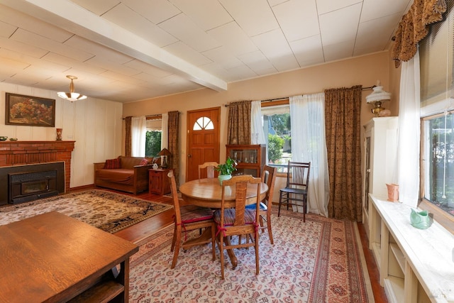 dining room featuring beamed ceiling, a wealth of natural light, and light hardwood / wood-style floors