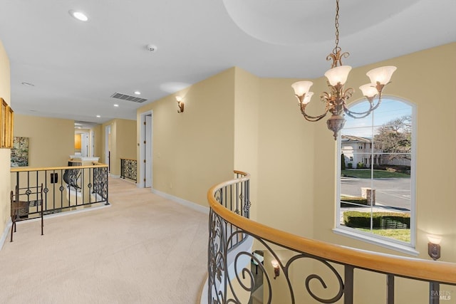 corridor featuring light colored carpet and a chandelier