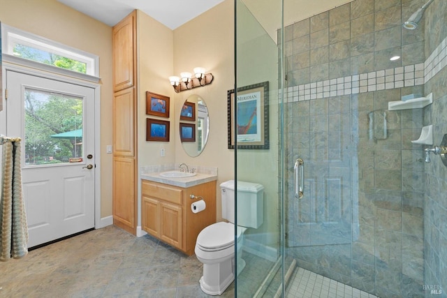 bathroom featuring vanity, a healthy amount of sunlight, an enclosed shower, and toilet