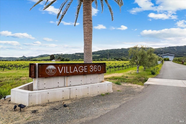 community / neighborhood sign with a mountain view and a rural view