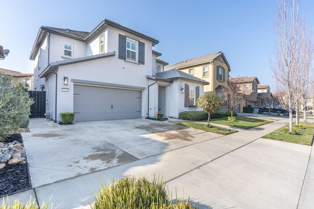 view of front facade featuring concrete driveway, fence, a garage, and stucco siding