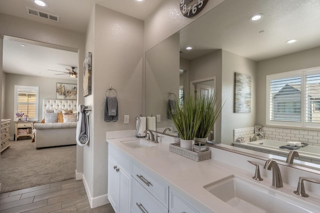 bathroom with vanity, hardwood / wood-style floors, ceiling fan, and a tub to relax in