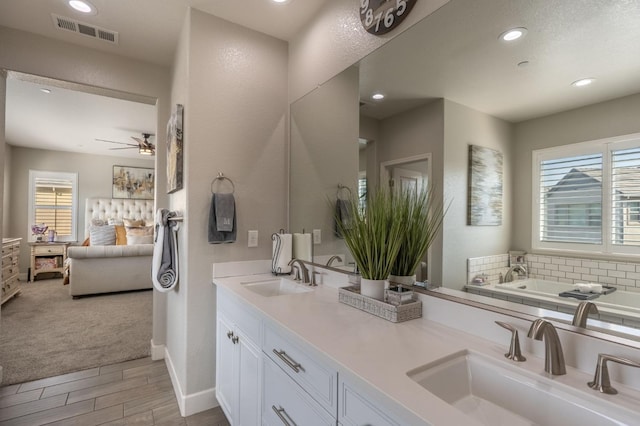 ensuite bathroom with visible vents, a sink, and a healthy amount of sunlight