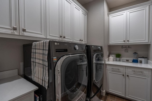 washroom with cabinet space and washer and dryer