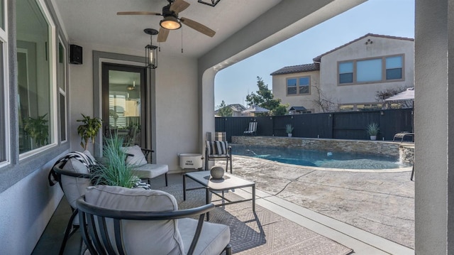 view of patio / terrace featuring a fenced in pool, pool water feature, and ceiling fan