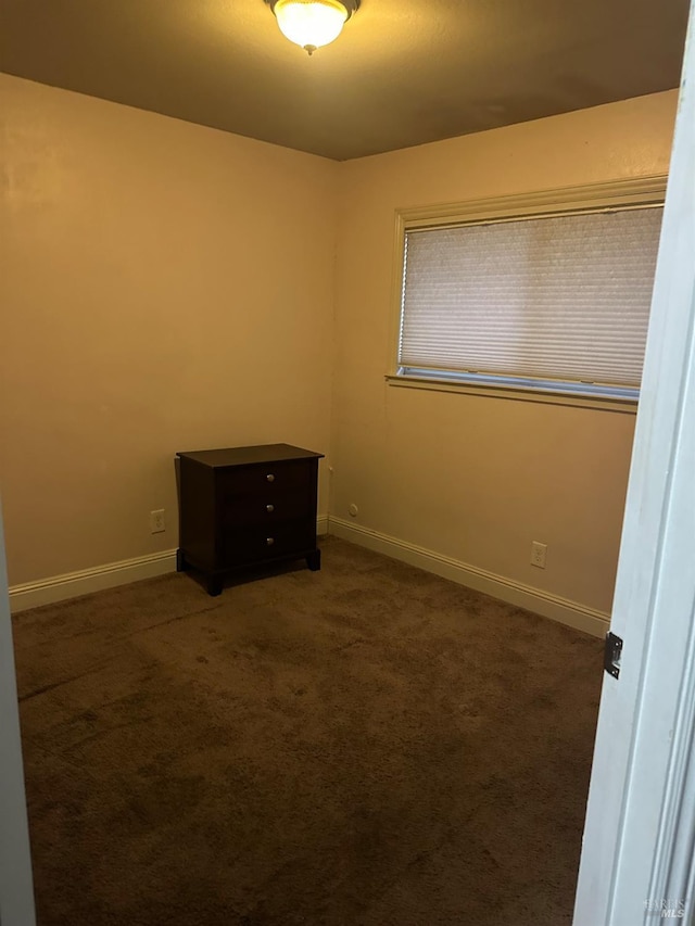 unfurnished room with dark carpet