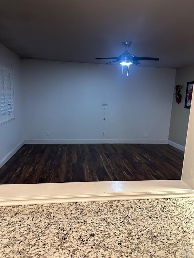 unfurnished room featuring dark hardwood / wood-style flooring and ceiling fan