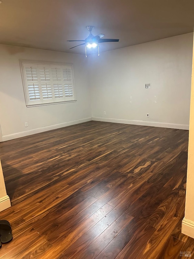 spare room featuring dark wood-type flooring and ceiling fan