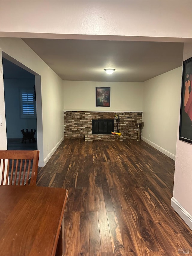 unfurnished living room with dark hardwood / wood-style flooring and a fireplace