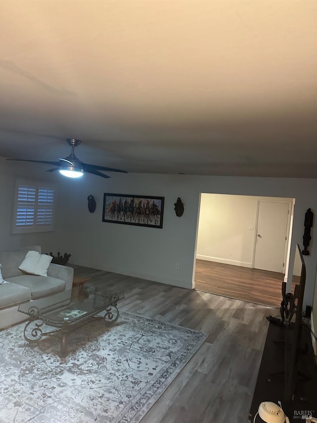 living room featuring ceiling fan and wood-type flooring