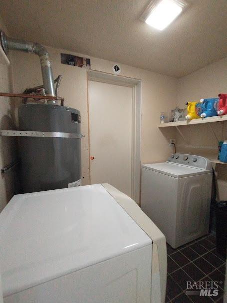 washroom with independent washer and dryer and dark tile patterned floors