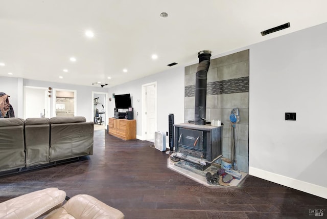 living room featuring dark wood-type flooring and a wood stove