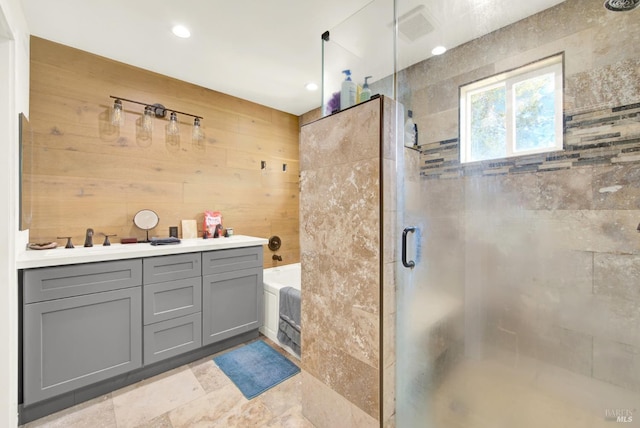 bathroom featuring vanity, wooden walls, and independent shower and bath