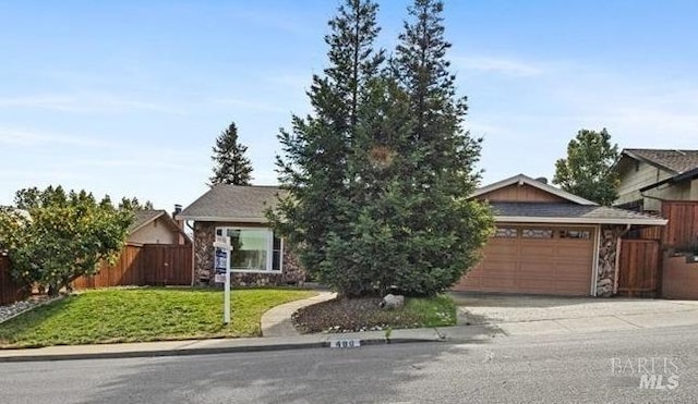 view of front of property with a garage, fence, concrete driveway, stone siding, and a front yard