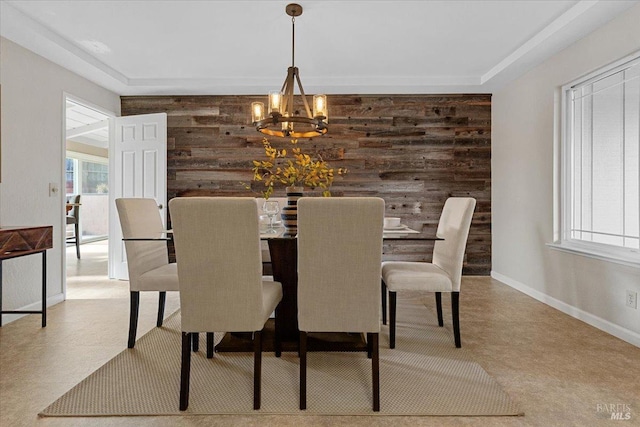 dining room with an inviting chandelier and wood walls