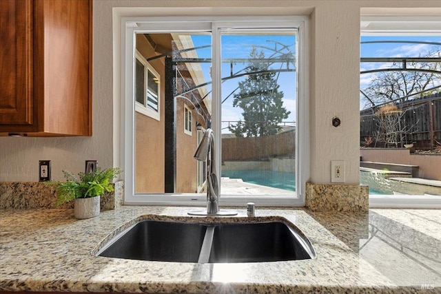 interior details featuring light stone countertops and sink