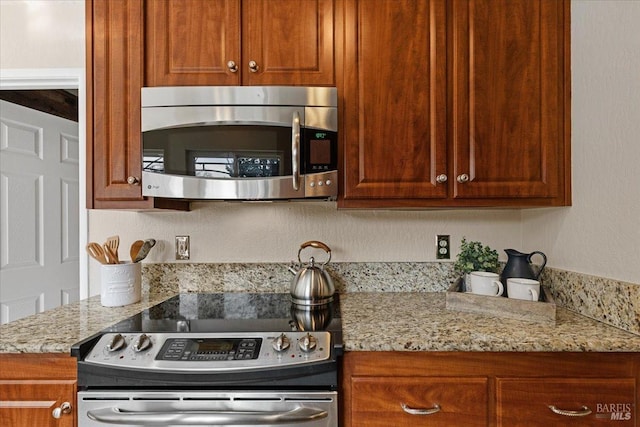 kitchen featuring stainless steel appliances and light stone countertops