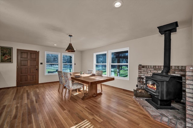 dining area featuring hardwood / wood-style floors and a wood stove