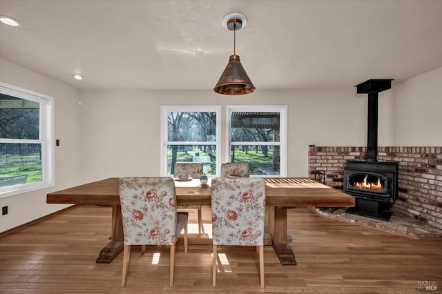 dining area featuring wood-type flooring and a wood stove