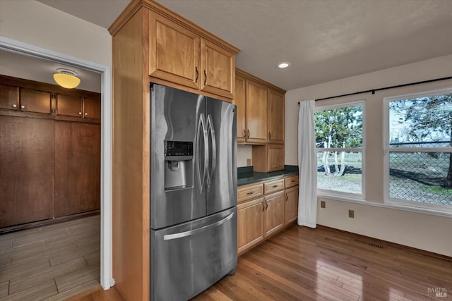 kitchen with stainless steel fridge and light hardwood / wood-style floors