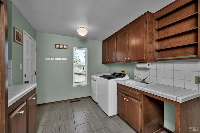 laundry area featuring cabinets, sink, and independent washer and dryer