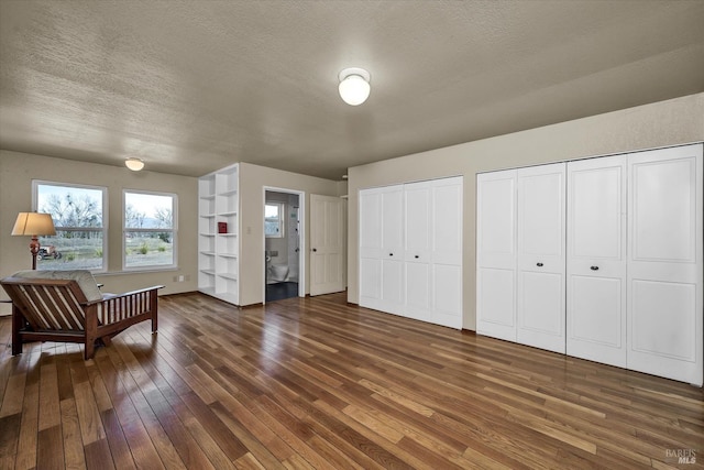 living area with dark wood-type flooring and a textured ceiling