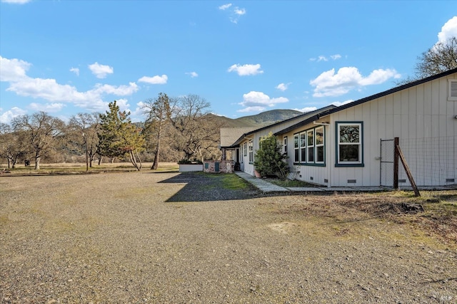 view of home's exterior with a mountain view and a lawn