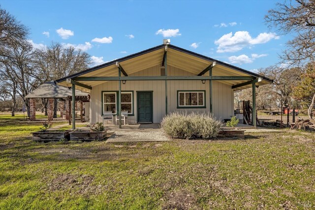 back of house with a yard and covered porch