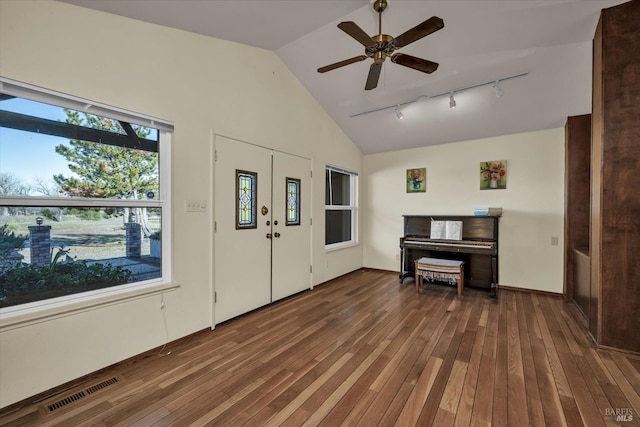 entrance foyer featuring rail lighting, high vaulted ceiling, dark hardwood / wood-style floors, and ceiling fan