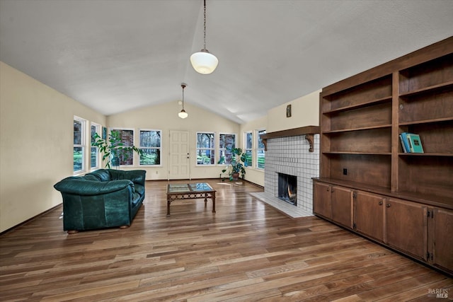 living room with hardwood / wood-style floors, a fireplace, and vaulted ceiling