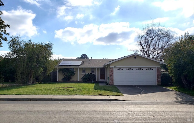 ranch-style house with brick siding, a front yard, roof mounted solar panels, a garage, and driveway