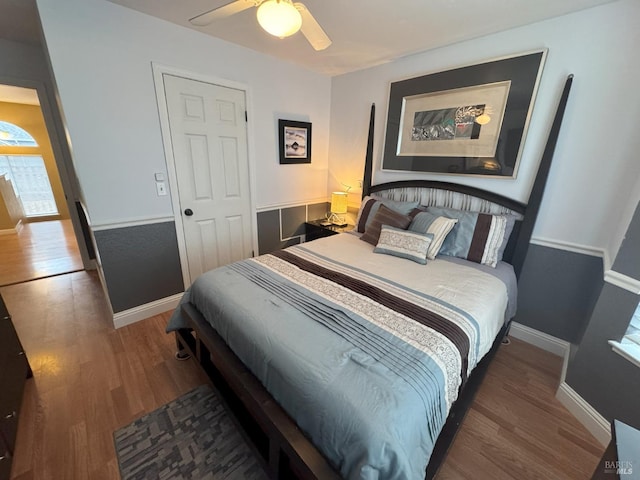 bedroom with dark hardwood / wood-style flooring and ceiling fan