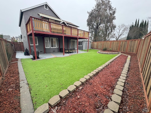 rear view of house with a shed, a yard, a patio, and a deck