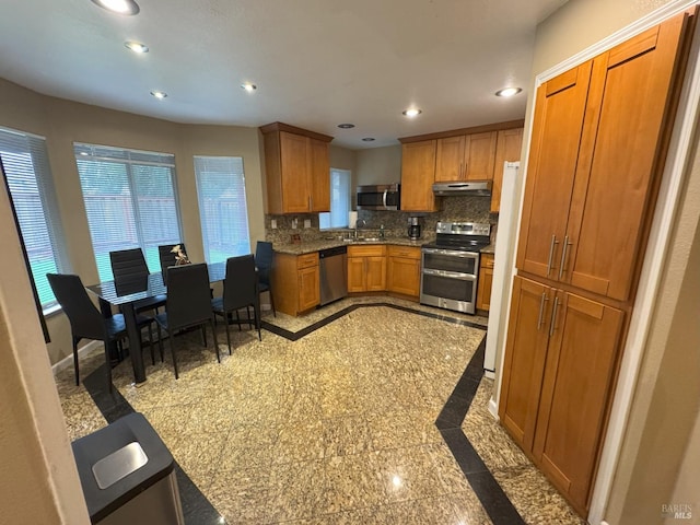 kitchen with tasteful backsplash, appliances with stainless steel finishes, and sink