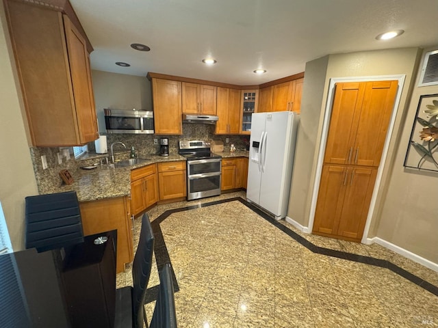 kitchen with sink, tasteful backsplash, light stone counters, white fridge with ice dispenser, and range with two ovens