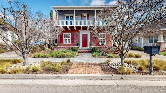 view of front of house with a balcony and brick siding