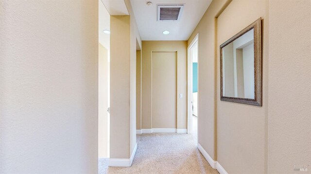 hallway with light colored carpet