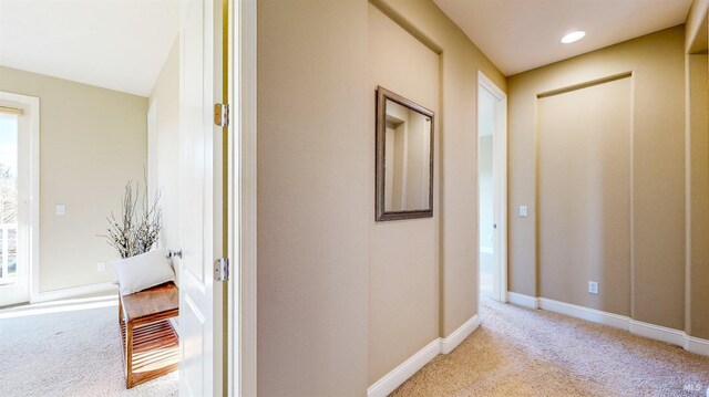 hallway featuring light colored carpet