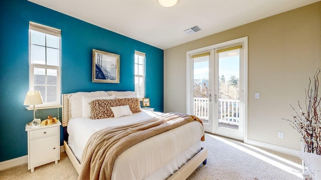 bedroom featuring light colored carpet, access to outside, french doors, and visible vents