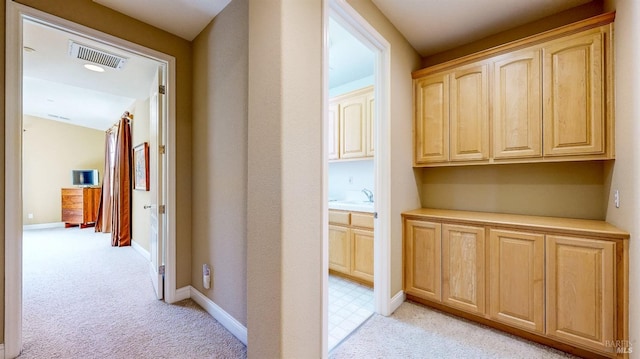 hall featuring light colored carpet