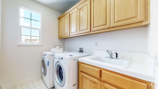 laundry room featuring cabinet space, a sink, washer and clothes dryer, and baseboards