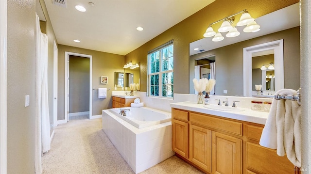 bathroom with vanity and tiled tub