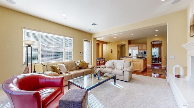 living area featuring baseboards, visible vents, arched walkways, a fireplace, and recessed lighting