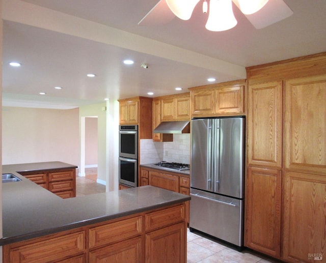 kitchen with sink, ceiling fan, appliances with stainless steel finishes, backsplash, and light tile patterned flooring