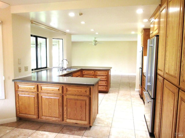 kitchen featuring sink, crown molding, light tile patterned floors, high end refrigerator, and kitchen peninsula